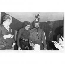 Black and white image, men in kilts at party 